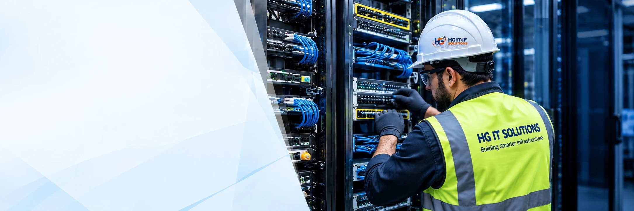 HG IT Solutions technician working beside enterprise network racks